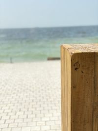 Wooden posts on beach against sky