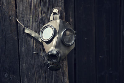 Close-up of gas mask hanging on door