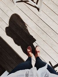 Low section of man standing on wood