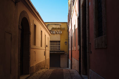 Empty street amidst buildings against clear sky