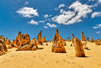 Rock formations on sand blue sky