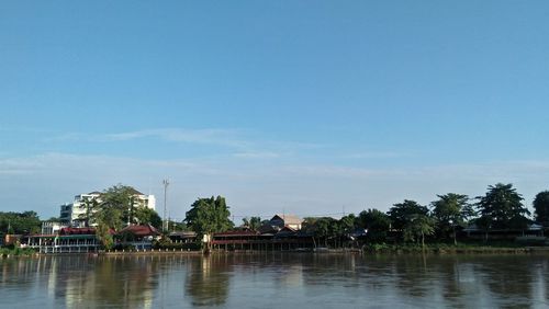 Scenic view of water and trees against sky