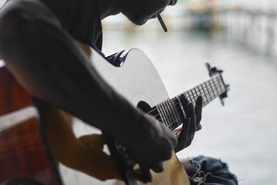 Close-up of man playing guitar