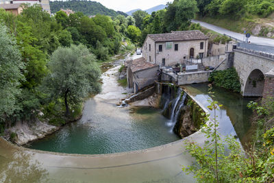 High angle view of river amidst trees and buildings