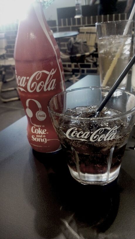 text, indoors, western script, communication, focus on foreground, close-up, food and drink, table, glass - material, red, restaurant, non-western script, drink, still life, incidental people, transparent, store, day, no people, cafe