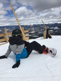 Low section of man skiing on snowcapped mountain against sky