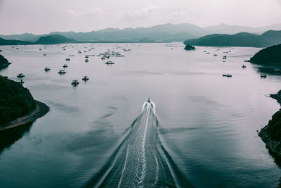 Motorboat sailing in sea against sky