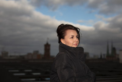 Young woman standing against sky during sunset