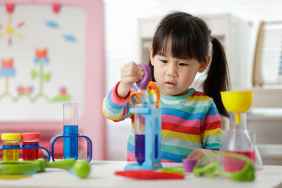 Young girl playing colour sorting and fine motor skill toy at home