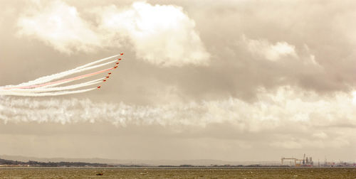 Airplane flying over landscape against sky