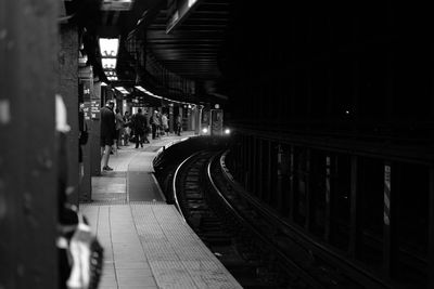 People on railroad station platform at night