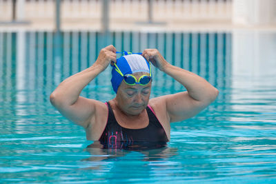 Senior woman wearing swimming goggles in pool