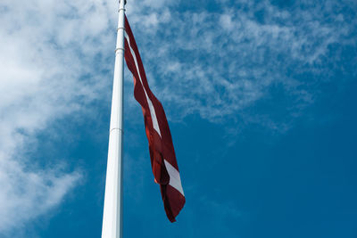 Low angle view of flag against blue sky
