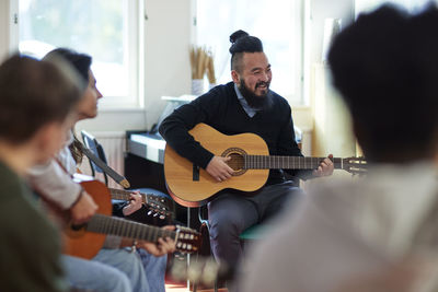 Teenagers attending guitar lesson