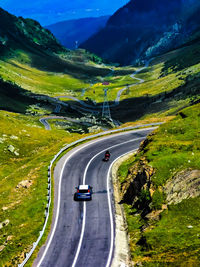 Vehicles on road along mountain