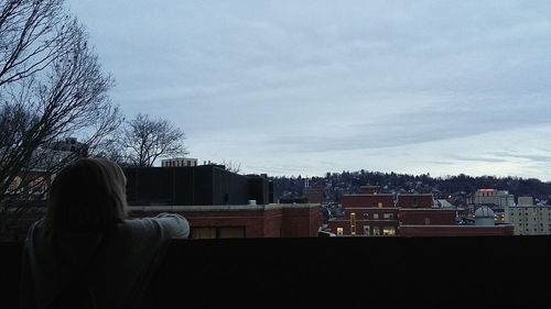 Woman in city against sky