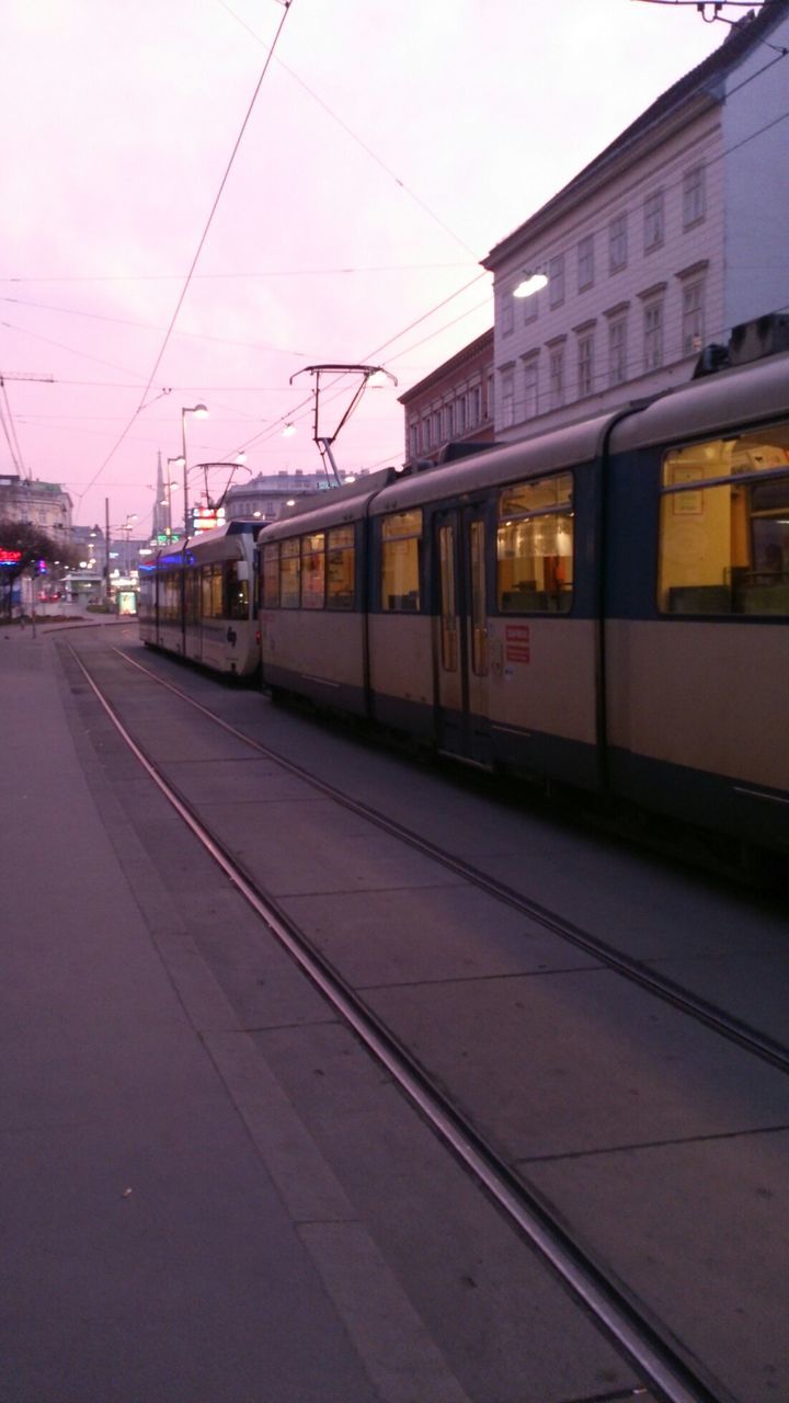 railroad track, transportation, public transportation, rail transportation, railroad station, railroad station platform, train - vehicle, power line, built structure, architecture, mode of transport, building exterior, sky, travel, passenger train, public transport, train, electricity pylon, railway track, tramway