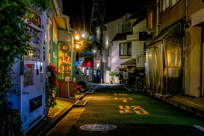 Illuminated street amidst buildings in city at night