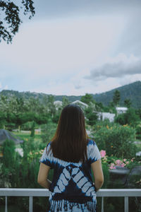 Rear view of woman standing against sky