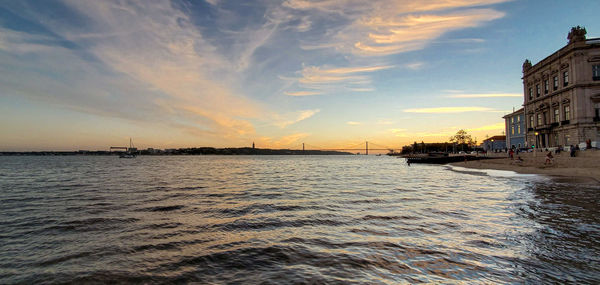 Scenic view of sea against cloudy sky during sunset