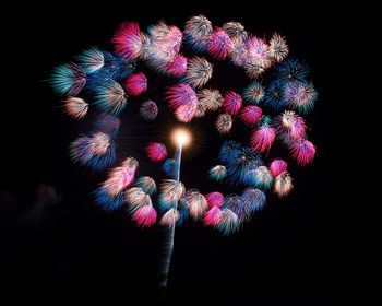 Low angle view of illuminated lights against black background