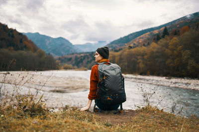 Rear view of man looking at mountains against sky