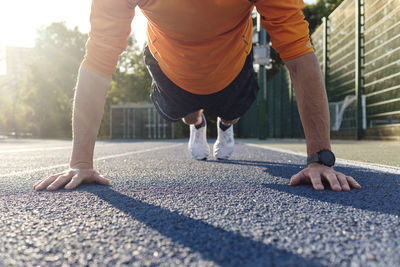 Sportsman exercising push-ups on track