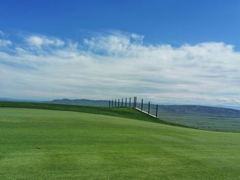 Scenic view of golf course against sky