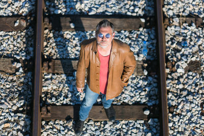 Lonely man standing on railroad tracks