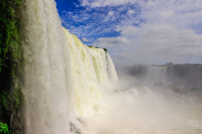 Scenic view of waterfall against sky