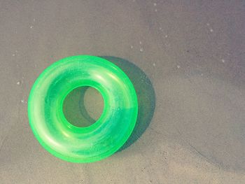 High angle view of green lifeguard ring on shore at beach