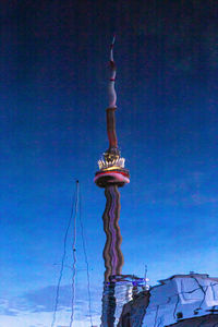 Low angle view of statue against building against clear blue sky