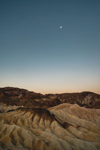 Scenic view of desert against clear sky during sunset