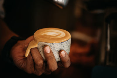 Close-up of hand holding coffee cup