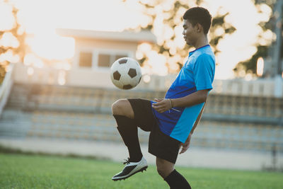 Woman playing soccer ball on grass