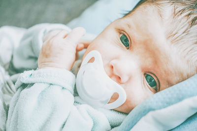 Portrait of baby girl lying on bed