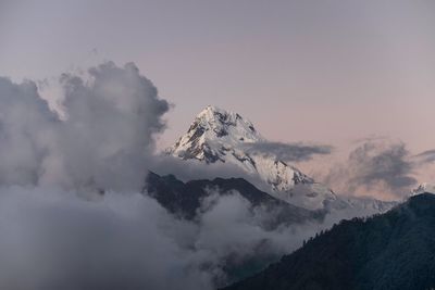 Low angle view of snow capped mountains against sky