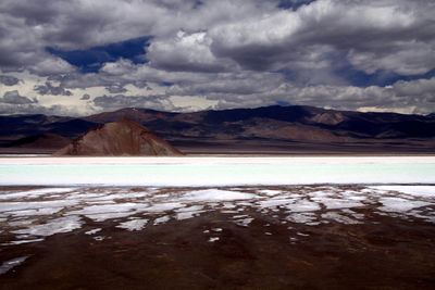 Scenic view of lake by mountains against sky