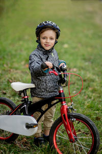 Portrait of boy riding bicycle on field