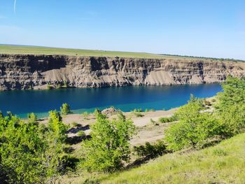 Scenic view of land and lake against sky