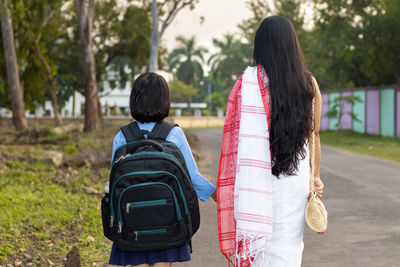 An indian school girl child going to school with her mother