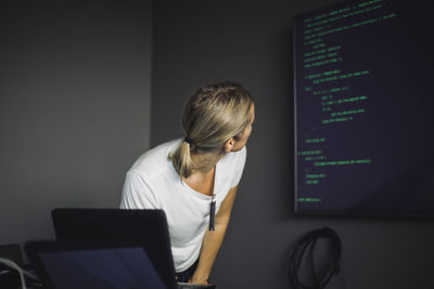 Female computer professional looking at projection screen in creative office