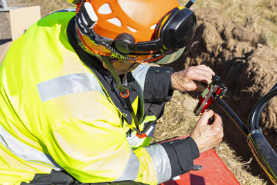 Worker in reflective clothing adjusting equipment