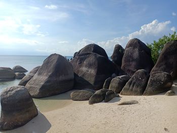 Rocks on beach against sky