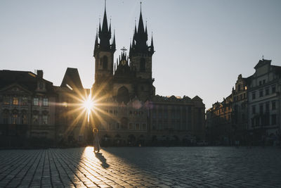 Woman walking at old town square during sunrise, in prague, czech republic.