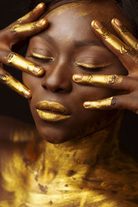 Close-up of woman in golden face paint