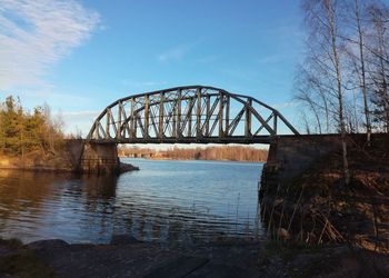 Arch bridge over river against sky