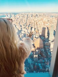 Rear view of woman with dog against cityscape
