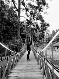 Side view of man standing on bridge