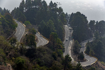 High angle view of road amidst trees against sky